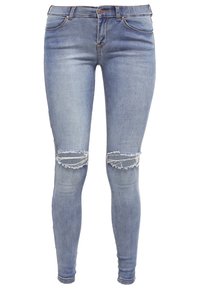 Jeans ajustados de mezclilla azul con detalles de rodillas rasgadas, talle alto, lavado claro y un sutil desvanecimiento para un aspecto usado.