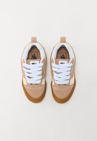 Brązowe i kremowe sneakersy z białymi sznurówkami, teksturowana cholewka z zamszu, gumowa podeszwa oraz wzmocniona zakładka na pięcie ułatwiająca zakładanie.