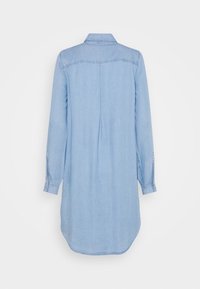 Ljusblå denimskjolklänning med långa ärmar, en knappad krage och en veckdetalj på ryggen. Avslutad med en rundad fåll.