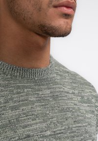 Knitted crew neck sweater in a grey-green hue with a textured pattern, featuring a ribbed neckline and smooth finish.