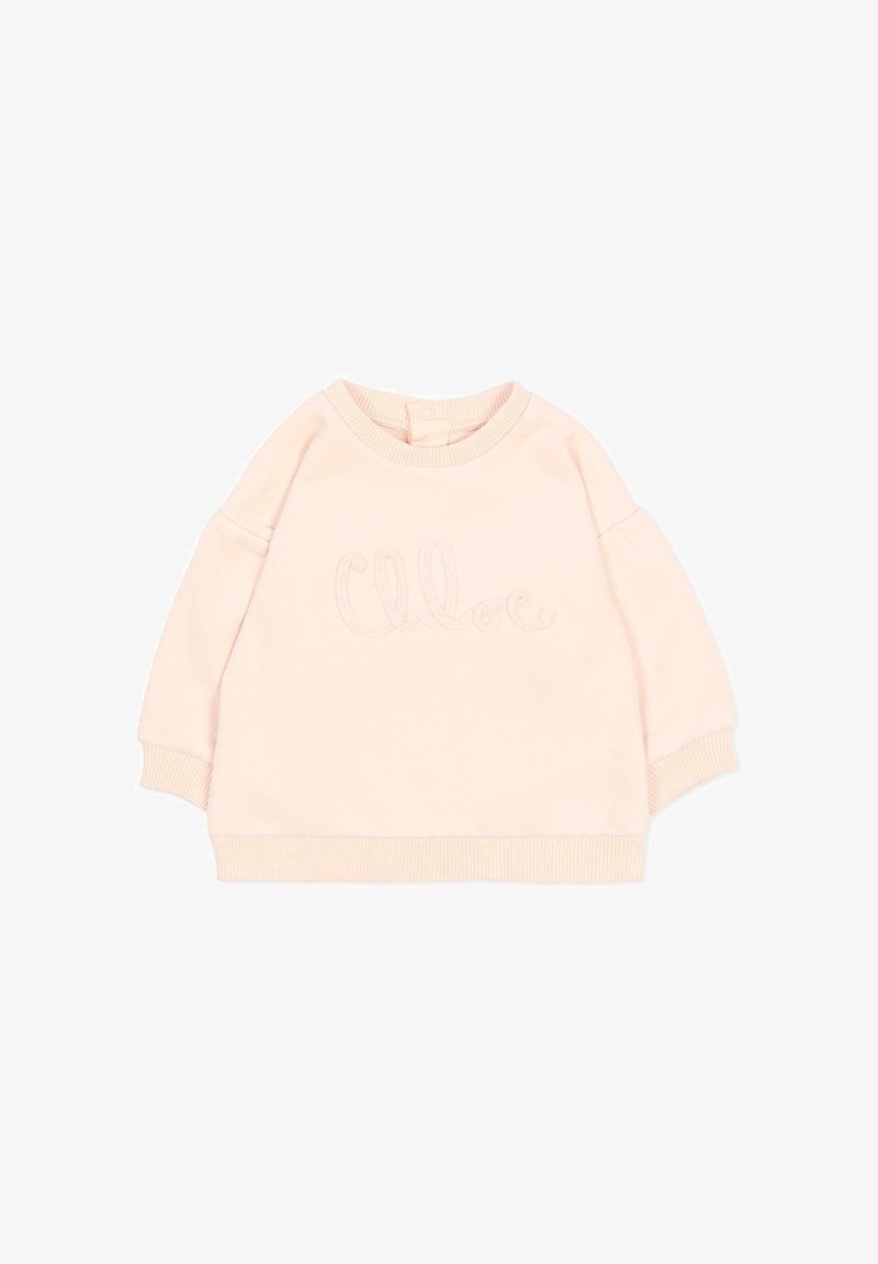 Sweat-shirt bébé à manches longues rose pâle avec poignets et ourlet côtelés, arborant un logo "Chloe" délicatement embossé sur le devant.