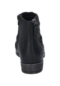 Botas negras de tobillo con textura de cuero liso, con cremallera en el lado y un tacón bajo apilado. Diseño simple sin patrones visibles.