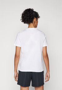 T-shirt bianco a maniche corte con scollatura rotonda, realizzato in cotone. La parte posteriore presenta una texture liscia e una vestibilità leggermente rilassata.