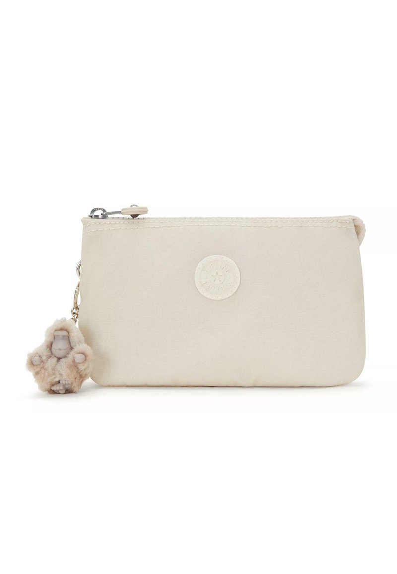 Beige zakje van stof, met een rond logo en een bedel die een kleine figuur in een fluffy outfit afbeeldt, met een ritssluiting.