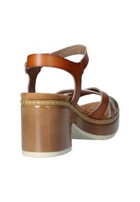 Sandalias de tacón de cuero marrón con parte trasera abierta, múltiples correas, plantilla acolchada y un tacón grueso con superficie suave.