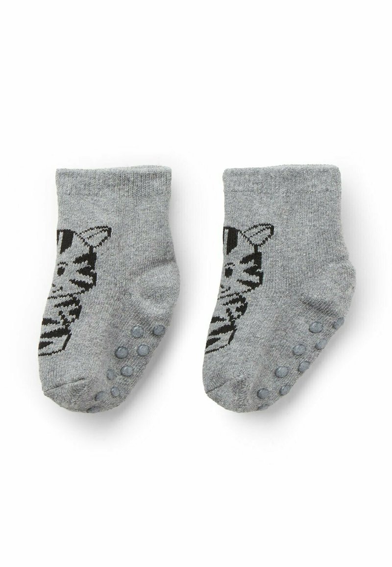 Un paio di calzini per neonati grigi con un design di faccia di gatto nero e puntini antiscivolo sulle suole, posizionati piatti su uno sfondo bianco.