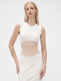 Hvit ermeløs kjole med korset-lignende beige overdel, med vertikale sømmer og en glatt tekstur, tettsittende silhuett, minimalistisk design.
