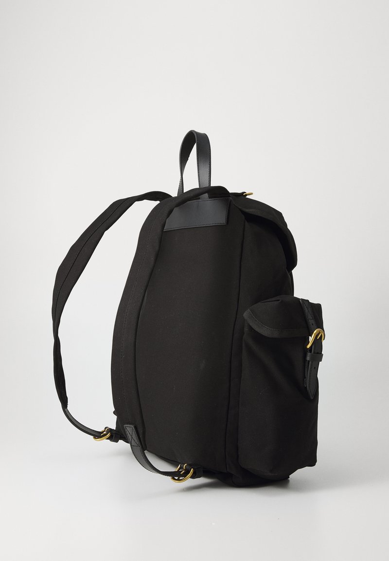 Zaino nero con un corpo in tessuto morbido e dettagli in pelle, tasca laterale e spallacci regolabili. Il design è strutturato e pratico.