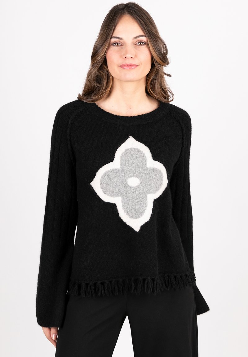 Black sweater with long sleeves, featuring a large, textured grey and white flower design at the center and a fringed hem.