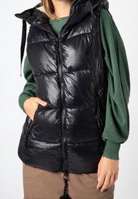 Schwarze Steppweste mit glänzendem Finish, Reißverschluss vorne und Kapuze. Verfügt über zwei Seitentaschen und Kordelzugakzente an der Kapuze.