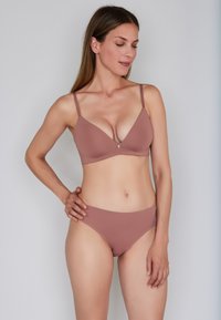 Mauve bikini set featuring a wireless, plunge bra with adjustable straps and seamless, mid-rise bikini bottoms. Smooth fabric texture.