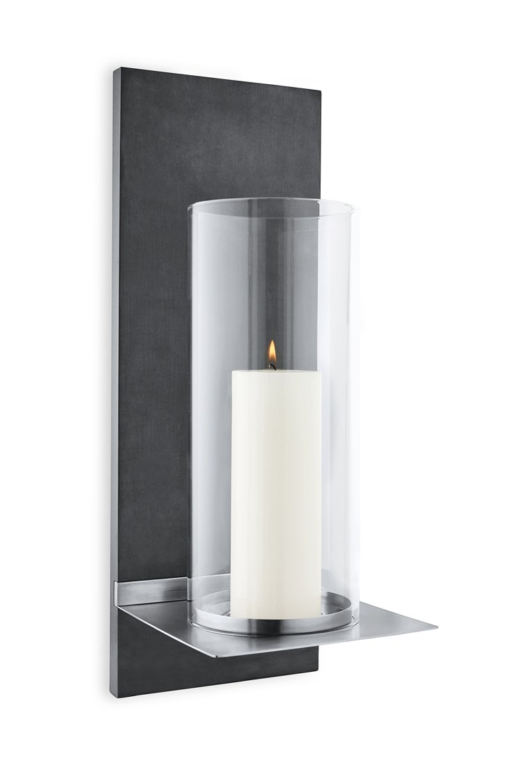 Die wandmontierte Kerzenhalterung verfügt über eine schwarze Metallrückplatte, einen transparenten Glaszylinder und eine weiße zylindrische Kerze mit flackerndem Licht.