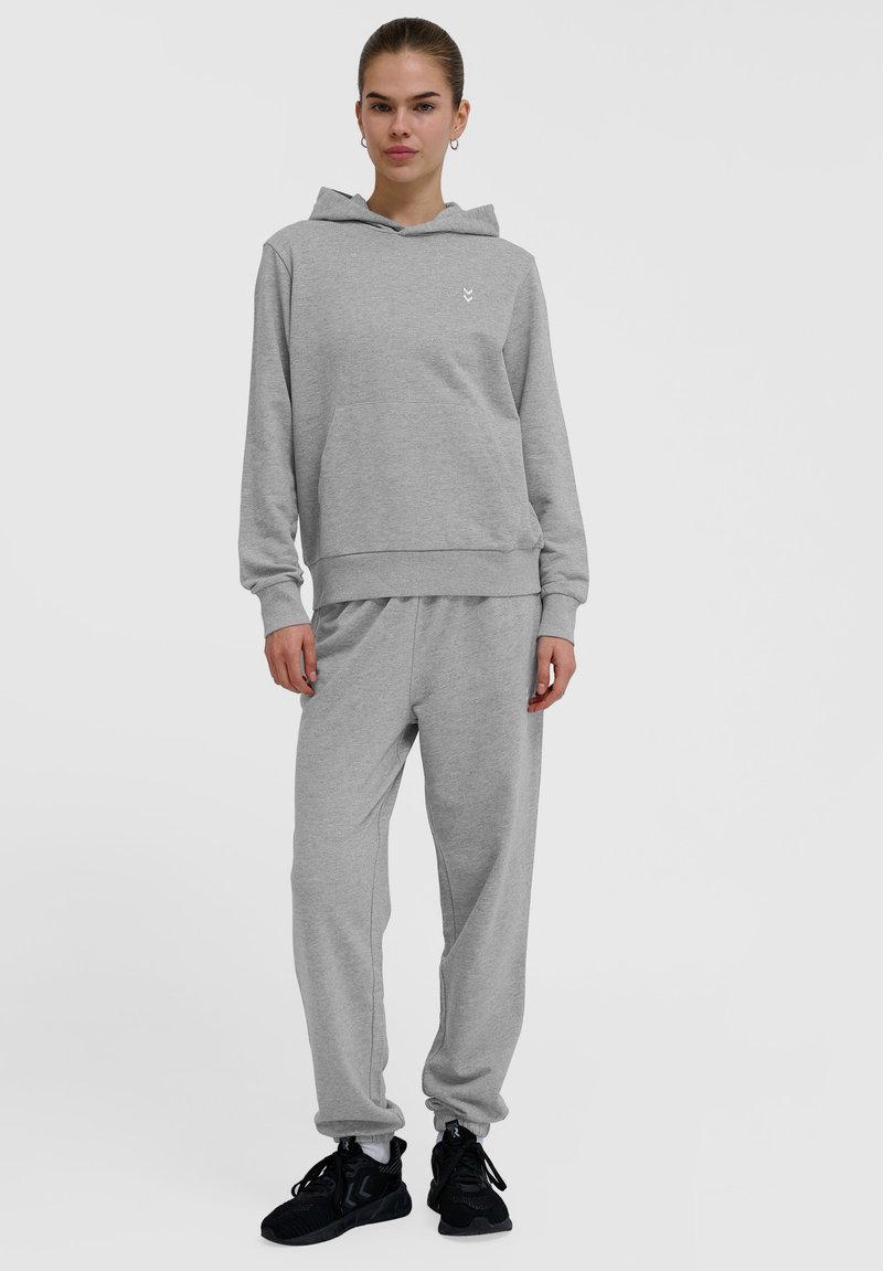 Set di felpa grigia e pantaloni della tuta realizzato in tessuto morbido. La felpa include una tasca frontale e un logo discreto; i pantaloni hanno una vita elastica.