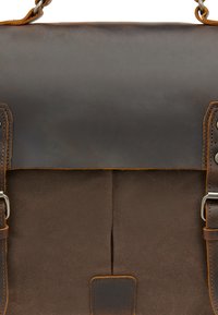 Brun læder- og canvas-messenger taske med låg, spænde-detaljer og kontrasterende syninger; har en glat overflade og forstærket design.