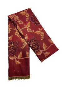 Écharpe rouge ornée de broderies florales en bordeaux, orange et or, avec des franges décoratives aux extrémités et une texture douce.