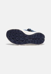 Sininen ja valkoinen lenkkaripohja, tähtikuviollinen päällyste, kumimateriaali, kevyesti teksturoitu pinta ja selkeä logo-imprintti.