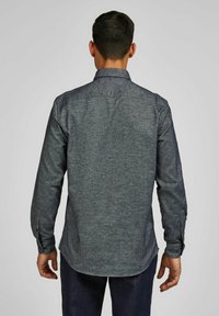 Donkerblauwe, lange mouw shirt met een gladde textuur, puntkraag en knoopmanchetten. Heeft een gebogen zoom en een subtiel stofpatroon.