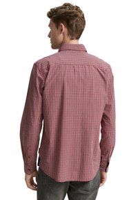 Rot-weißer kariertes Langarmhemd mit klassischem Kragen und Knopfmanschetten, ausgestattet mit einer geraden Rückenblende und einem abgerundeten Saum.