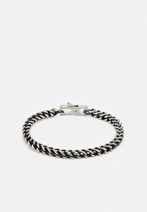 Bracciale in metallo a catena di colore nero con design a torsione, dotato di una chiusura sicura. La superficie liscia e la finitura lucida esaltano il suo aspetto moderno.