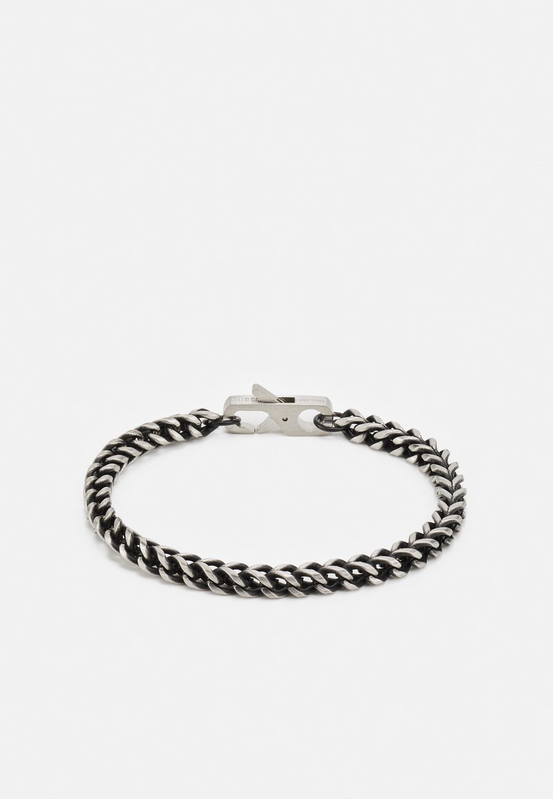 Bracelet en métal noir avec un design torsadé, doté d'un fermoir sécurisé. Sa texture lisse et sa finition polie accentuent son apparence moderne.
