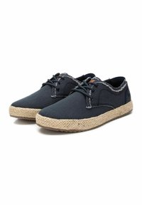 Zapatillas de lona azul oscuro con suela de yute trenzada, que presentan un borde texturizado y deshilachado y cordones negros. Punta redondeada y detalles de costura mínimos.