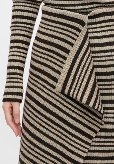 Vestido de malha riscada com uma bainha assimétrica, apresentando riscas verticais alternadas em castanho escuro e bege. Tecido ribado texturizado, ajuste slim.