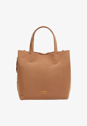 Beżowa torba tote wykonana z gładkiego materiału, z dwoma uchwytami na górze, złotym logo marki oraz minimalistycznym designem bez widocznych zapięć czy wzorów.