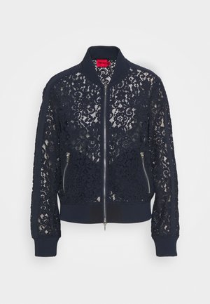 Veste bomber en dentelle bleu marine avec motifs floraux, col et poignets côtelés, fermeture éclair devant et deux poches zippées.