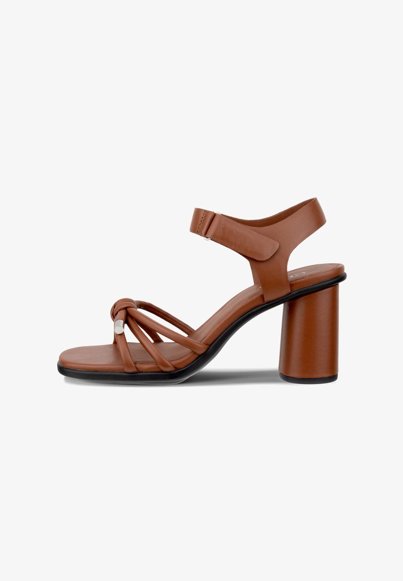 Sandálias de salto alto castanhas com um amplo salto bloco, apresentando tiras em cruz e uma tira no tornozelo com fivela. Material de couro liso, design minimalista.
