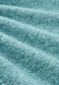 Strukturiertes blaues Gewebe mit einem gewebten Muster, das weiches, flauschiges Garn und sanfte Wellen für eine dreidimensionale Optik aufweist.