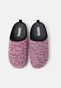 Rosa ulltofflor med texturerad yta och svart foder, med en dragflik för enkel påtagning och "CAMPER"-logotyp på innersulan.