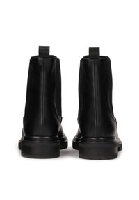 Black leather ankle boots with elastic side panels, pull tabs at the back, and textured soles. Minimalist design with a sleek silhouette.