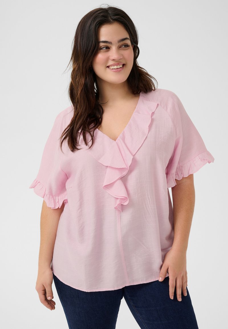 Blusa rosa chiaro con scollatura a righe e maniche corte, realizzata in tessuto morbido. Design a V con una vestibilità comoda, abbinata a jeans scuri.