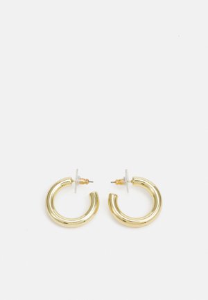 Guldörhängen i form av ringar med en slät, glänsande yta. Cirkulär design med en liten stötta och genomskinlig bakgrund för säker användning.