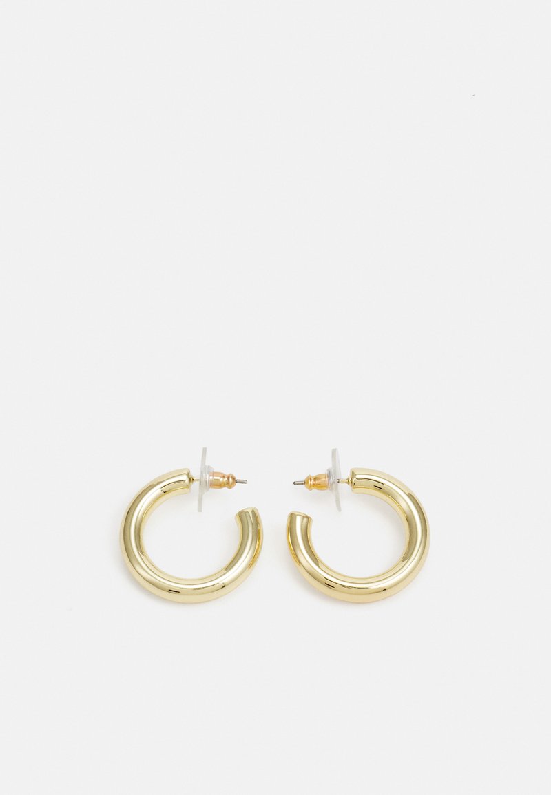 Guldörhängen i form av ringar med en slät, glänsande yta. Cirkulär design med en liten stötta och genomskinlig bakgrund för säker användning.