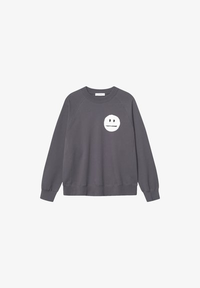 Sudadera gris de algodón, con un gráfico blanco redondo que presenta una cara minimalista en el pecho, puños y dobladillo acanalados.