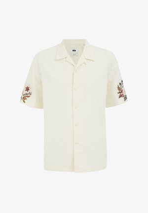 Kratki rukavi, košulja na gumbe od kremaste tkanine, sa cvjetnim vezom na rukavima u prigušenim bojama. Ravni rub.