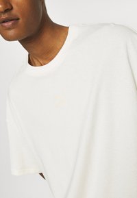 Puma CLASSICS BOXY TEE - T-Shirt print - off-white
