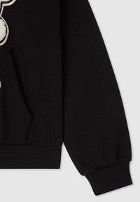 Felpa nera con polsini e orlo a coste, tasca frontale e dettaglio in pelliccia. Realizzata in morbido cotone.