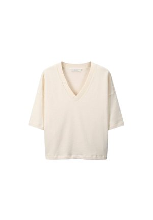T-shirt V en crème en coton doux. Manches courtes, coupe décontractée, encolure ribbed et texture lisse. Sans motifs ni accents.