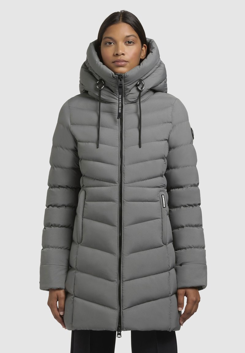 Grijze gewatteerde parka met een hoge kraag, ritssluiting, verstelbare capuchon en zijzakken. Kenmerkt zich door een chevronquiltpatroon en een elegante stof.