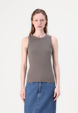 Haut gris à côtes sans manches avec un col rond, fabriqué en tissu extensible, design ajusté, porté avec une jupe en denim bleue.