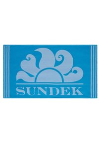 Asciugamano da spiaggia blu con un design solare azzurro e testo "SUNDEK". Presenta strisce lungo i lati. Texture morbida, forma rettangolare.