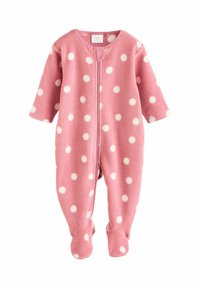 Combinaison en polaire rose avec de grands pois blancs, zip frontal, manches longues et pieds pour plus de chaleur et de confort.