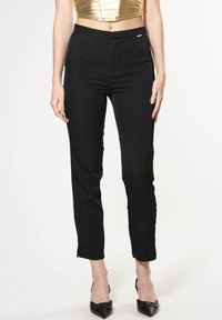 Pantaloni neri su misura con una vestibilità slim, vita media e sottili spacchi laterali all'orlo. Tessuto morbido con un piccolo accento dorato in vita.
