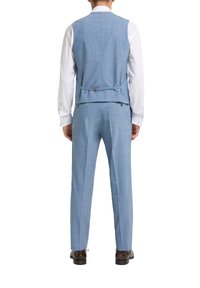 Hellblauer maßgeschneiderter Anzug mit einer taillierten Weste und Hose, glatte Textur, Rückendetail mit Schnalle und Riemen. Darunter ein weißes Hemd.