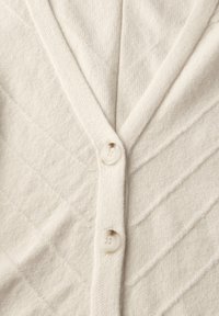 Cremfarbener Cardigan mit V-Ausschnitt, strukturiertem schrägem Rippenmuster und drei Knöpfen vorne. Hergestellt aus einem weichen Strickmaterial.