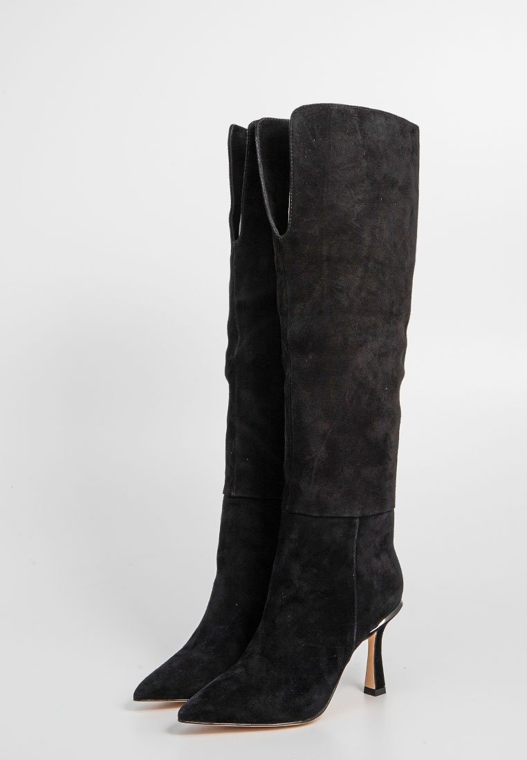 Schwarze Wildleder-Stiefel bis zum Knie mit spitzen Zehen und schlanken hohen Absätzen, auf einem schlichten hellen Hintergrund aufrecht stehend.