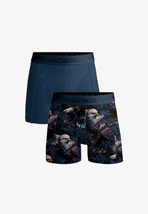 Deux boxers pour hommes, l'un en bleu marine uni, l'autre en bleu marine avec un imprimé détaillé d'aigle, tous deux avec une ceinture noire portant l'inscription « MUCHACHOMALO ».
