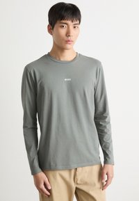 Grau langärmliges T-Shirt aus weichem Material mit rundem Halsausschnitt und kleinem weißen "BOSS"-Logo auf der Brust.